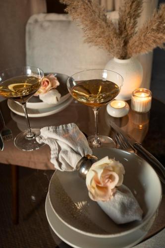 ハヴォルスヴォルールにあるAURA Retreat Icelandのワイングラス2つと料理の皿が置かれたテーブル