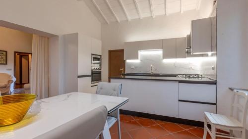 a kitchen with white cabinets and a table and chairs at Podere del Monte in Amelia