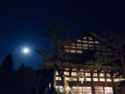 a full moon over a building at night at 銭がめ in Kanazawa