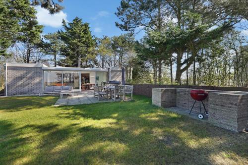 un patio trasero con barbacoa y una casa en Alexanderpark 54 - Ouddorp NOT INTENDED FOR COMPANY OR WORK-RELATED STAYS, en Ouddorp
