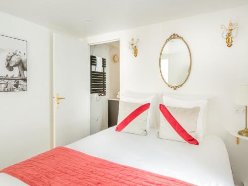 - une chambre blanche avec un lit et un miroir mural dans l'établissement Merveil - Luxury Suite - Louvre - Aboukir II, à Paris