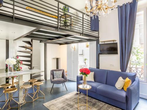 - un salon avec un canapé bleu et un escalier dans l'établissement Merveil - Luxury Suite - Louvre - Aboukir II, à Paris