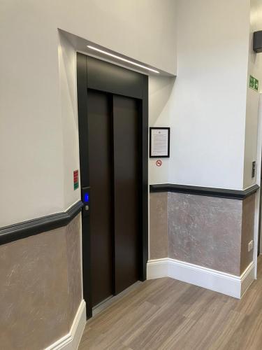 a elevator in a building with a black door at MSK Elite in London