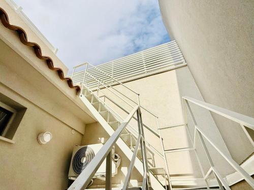 a spiral staircase of a building next to a building at La casa di Tina in Pachino