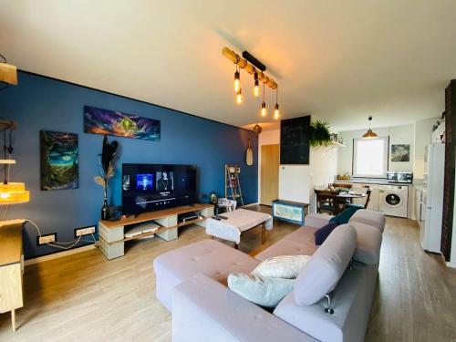 un salon avec un canapé blanc et une télévision dans l'établissement Casa Botanica, à Angers