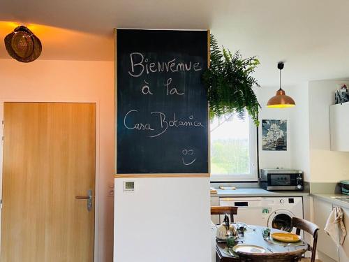 une cuisine avec un panneau en tableau noir sur un réfrigérateur dans l'établissement Casa Botanica, à Angers