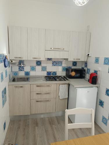 a kitchen with white cabinets and a stove top oven at Olly Guest House a Recco - Golfo Paradiso in Recco