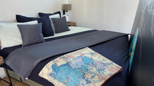 a bed with a blue blanket with a map on it at Plassenzicht Logies & Sloepverhuur in Loosdrecht