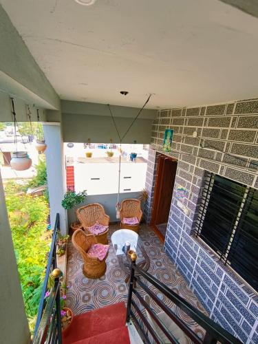 a balcony with a table and chairs and a brick wall at Veeru Homestay in Hospet