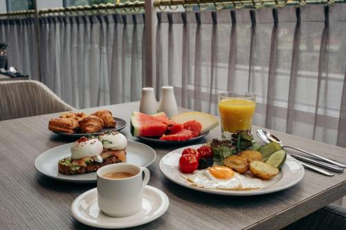 a table with plates of breakfast foods and a cup of coffee at Radisson Blu Latvija Conference & Spa Hotel, Riga in Rīga