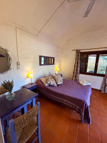 a bedroom with a bed and a table and two lamps at Posada Buen Camino in Nono