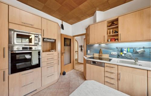 a kitchen with wooden cabinets and a sink at Nice Home In Rangsdorf With Wifi in Rangsdorf