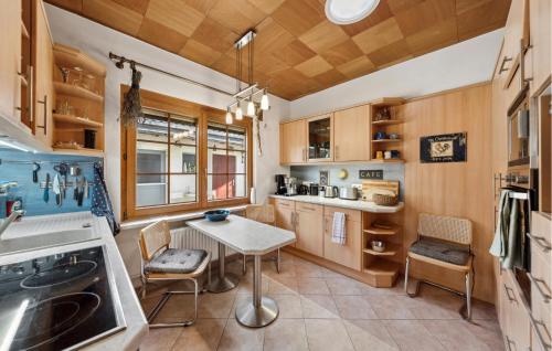 a kitchen with wooden cabinets and a table and chairs at Nice Home In Rangsdorf With Wifi in Rangsdorf