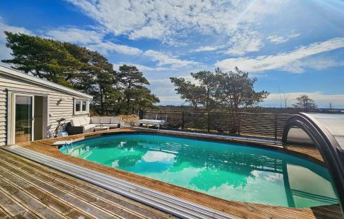 a swimming pool on a deck next to a house at Beautiful Home In Gressvik in Gressvik