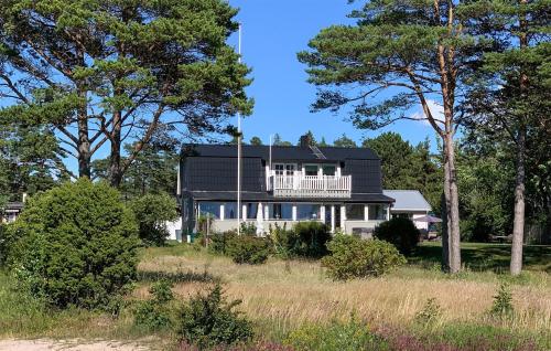 a house with a black roof and a balcony at Cozy Home In Tofta With Wifi in Tofta