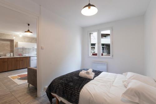 une chambre blanche avec un lit et une cuisine dans l'établissement Cabana & Le Carrefour Lyonnais - Metro 5 min, à Villeurbanne