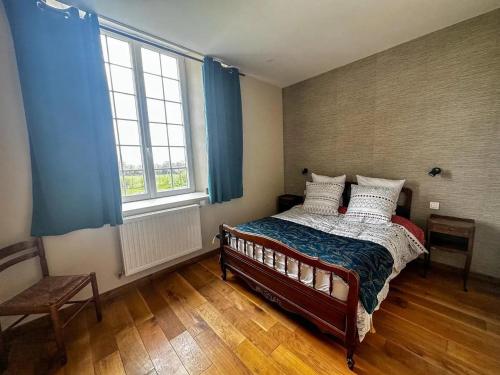 ein Schlafzimmer mit einem Bett und einem großen Fenster in der Unterkunft Maison confortable à Saint-Pierre-du-Mont avec jardin in Saint-Pierre-du-Mont