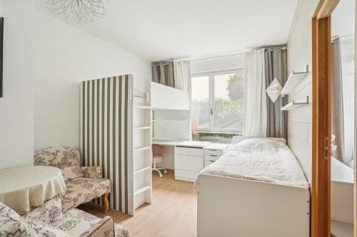 une petite chambre avec un lit et un bureau dans l'établissement Place Victor Hugo - Mesnil 1bdr by B'Your Home, à Paris