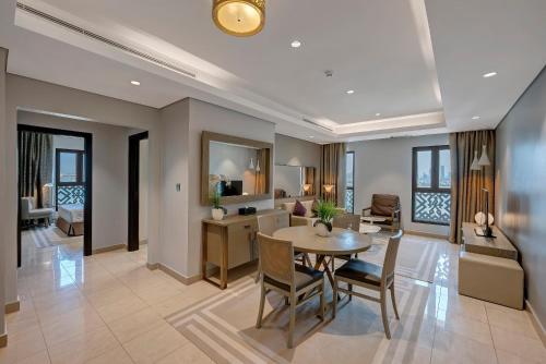a dining room and living room with a table and chairs at Wyndham Residences The Palm in Dubai