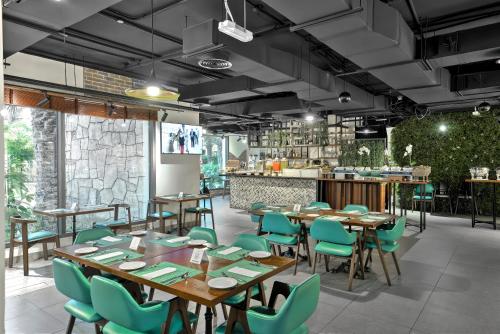 a restaurant with wooden tables and green chairs at Wyndham Residences The Palm in Dubai