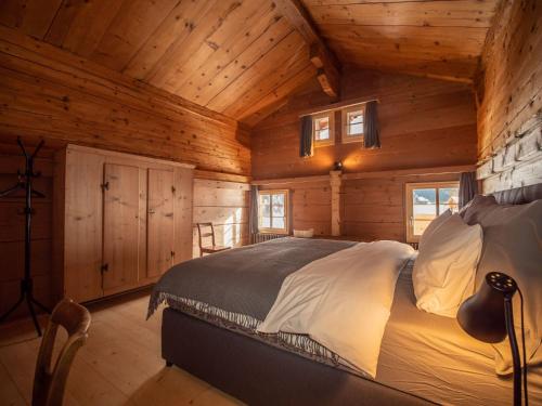 a bedroom with a bed in a wooden cabin at Chalet Glacier in Gsteig