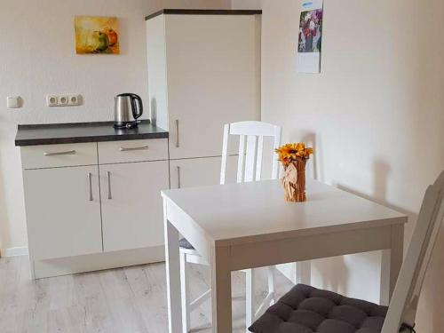 cocina con mesa blanca y silla blanca en Ferienwohnung Mittermayer, en Ribnitz-Damgarten