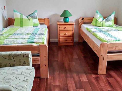 una habitación con dos camas y una mesa con lámpara en Ferienwohnung Mittermayer, en Ribnitz-Damgarten