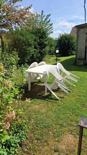 un banco blanco sentado en el césped en un patio en Bienvenue, en Marly
