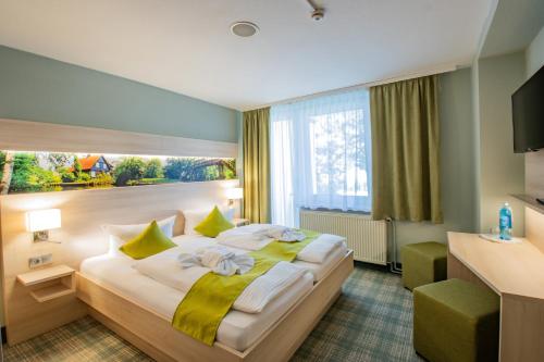 a hotel room with a large bed with a window at Ferien Hotel Spree-Neisse in Neuhausen