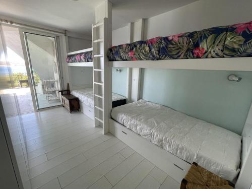 Cette chambre comprend 2 lits superposés et un balcon. dans l'établissement Villa 10 pers - Vue Mer - parking - clim - piscine, à Roquebrune-sur Argens