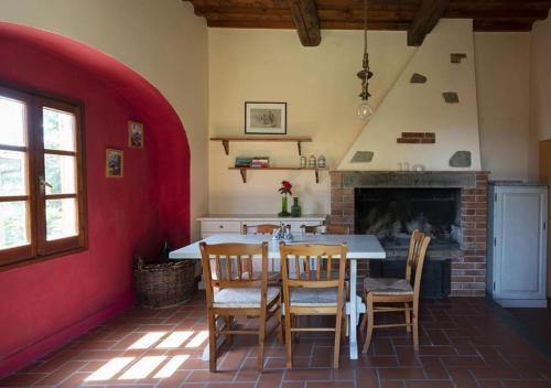 cocina con mesa, sillas y chimenea en Borgo La Capraia, en Castelfranco di Sopra