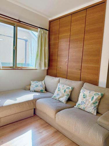a living room with a couch and two windows at keisei koiwa little garden in Tokyo
