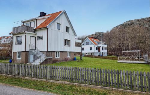 a house with a fence in front of a yard at 3 Bedroom Amazing Home In Dyrön in Stora Dyrön