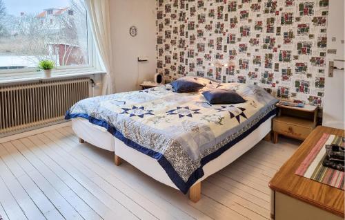 a bedroom with a bed with a quilt on it at 3 Bedroom Amazing Home In Dyrön in Stora Dyrön