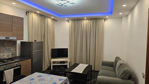 a kitchen with a living room with a couch and a television at Aria Casa Vacanza in Casalmaggiore
