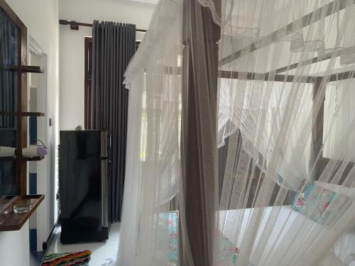 a bedroom with a bed with white curtains at Royal Palace Mirissa in Mirissa