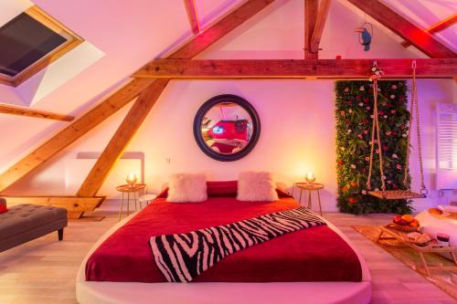 ein Schlafzimmer mit einem roten Bett und einem Weihnachtsbaum in der Unterkunft Suite Romantique 45m2-Amiens Centre-SPA & Parking in Amiens