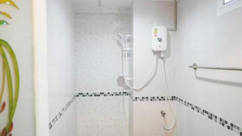 a bathroom with a shower with a phone on the wall at RQ Suvarnabhumi Airport by Collection O in Bangkok