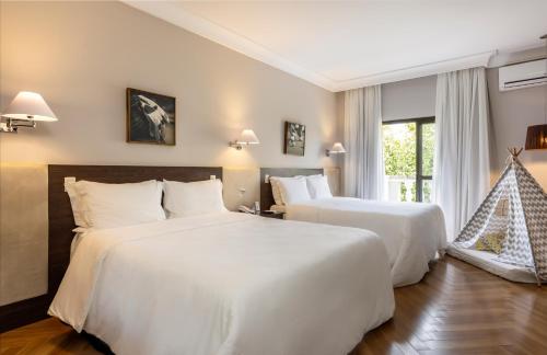 a hotel room with two beds and a window at Wish Foz do Iguaçu in Foz do Iguaçu