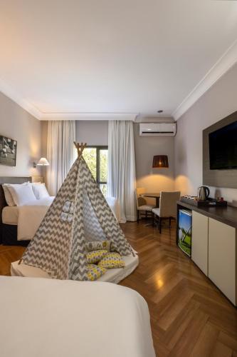 a hotel room with a bedroom with a bed and a tv at Wish Foz do Iguaçu in Foz do Iguaçu