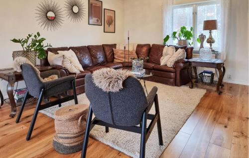 a living room with a leather couch and chairs at 3 Bedroom Cozy Home In Alingsås in Alingsås