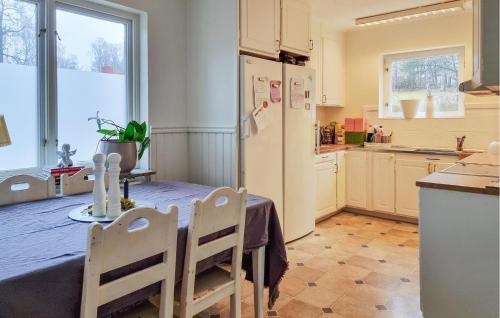 a kitchen with a table with chairs and a refrigerator at 3 Bedroom Cozy Home In Alingsås in Alingsås