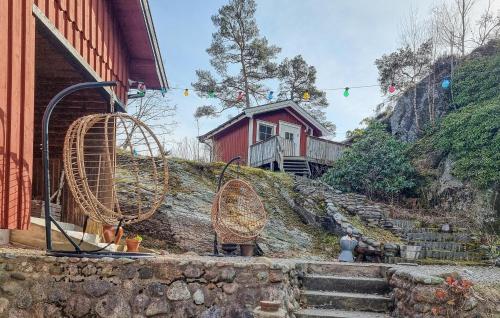 a house on a hill with two largewheels in front of a building at 2 Bedroom Lovely Home In Henån in Henån