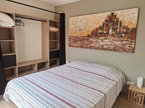 une chambre avec un lit et un tableau au mur dans l'établissement Pavillon 4 personnes entièrement rénové proche plage, à Six-Fours-les-Plages