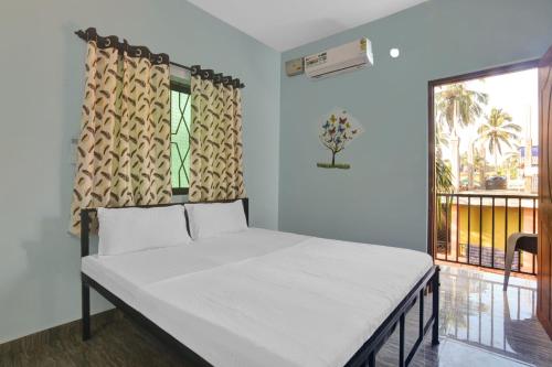 a bed in a room with a window at Hotel O Sai Leela in Goa
