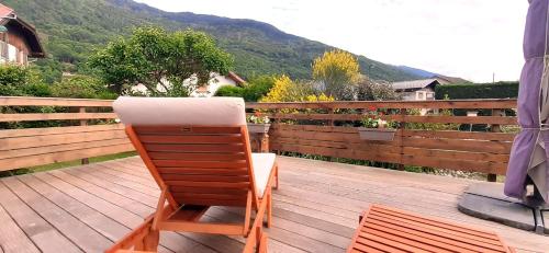 a wooden chair sitting on a wooden deck at Au Ptit bonheur in Grignon