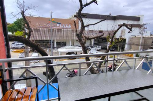 a table and chairs on a balcony with a building at Inn Ka Kay Mame Puerto Princesa in Puerto Princesa City