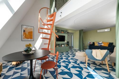 a living room with a staircase and a table and chairs at MÁK Kismaros in Kismaros