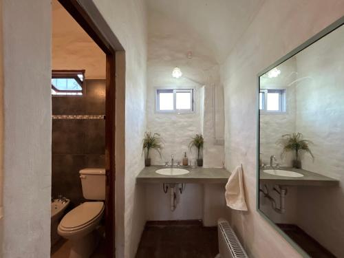 a bathroom with two sinks and a toilet at Posada Buen Camino in Nono