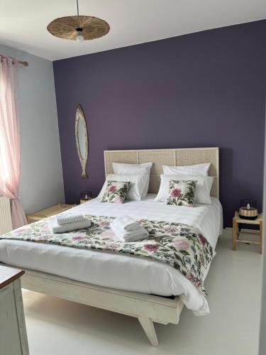 a bedroom with a large bed with purple walls at Maison rénovée avec garage et jardin, proche centre ville - La Tremblade in La Tremblade